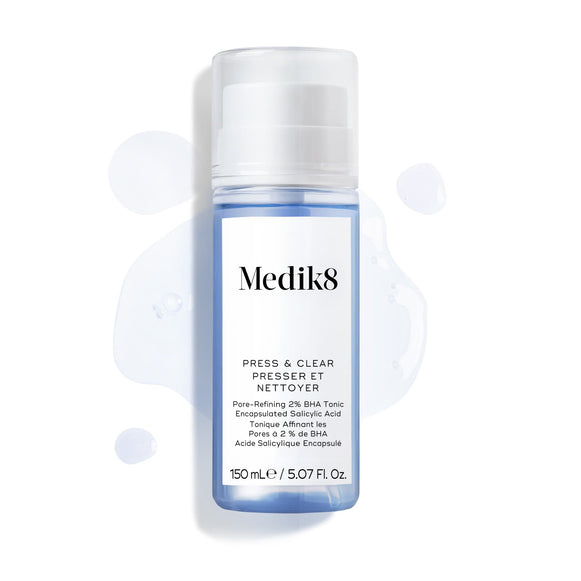 Lahvička tonika Medik8 Press & Clear (150 ml) je zobrazena na bílém pozadí s kapkami modrého tonika kolem ní. -17