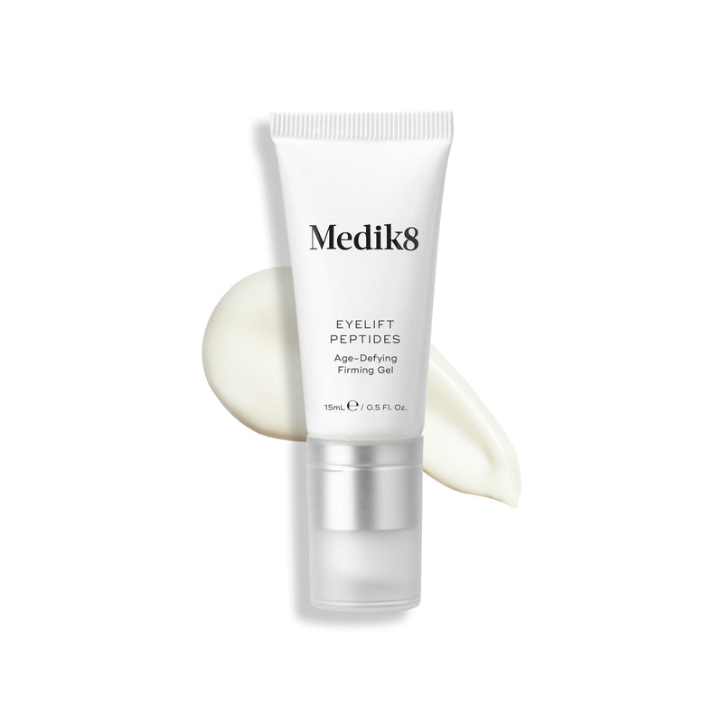 Tuba Eyelift Peptides stojí vzpřímeně, s texturou produktu zobrazenou jako vzorek za ní.