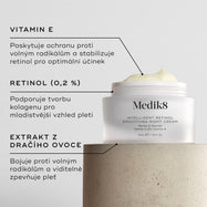Detailní záběr na noční vyhlazující krém Intelligent Retinol, na kterém je vidět bílá nádobka s krémem a štítky s uvedením složek. Pozadí tvoří světlý povrch s texturou. V textových rámečcích jsou zvýrazněny položky VITAMIN E, RETINOL (0,2 %) a EXTRAKT Z DRAGON FRUIT.