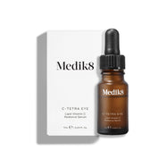 Láhev séra Medik8 C-Tetra Eye Lipid Vitamin C Radiance Serum stojí na čistém bílém pozadí před svým bílým obalem.