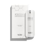 Bílá pumpičková lahvička r-Retinoate Day & Night Eye Serum stojí vedle své odpovídající bílé krabičky.