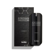 Lahvička Medik8 r-Retinoate Intense Youth Activating Cream stojí vedle své černé vnější krabičky, která obsahuje bílé grafiky chemických hexagonálních struktur a texturovaný vlnitý vzor.