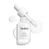 Průhledná skleněná lahvička séra Liquid Peptides je zobrazena s vyjmutým kapátkem položeným vedle ní. Kolem jsou viditelné kapky séra, které zdůrazňují jeho texturu.