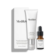 Bílá kartonová krabička stojí vedle bílé tuby Balance Moisturiser a malé hnědé skleněné lahvičky Glycolic Acid Activator.