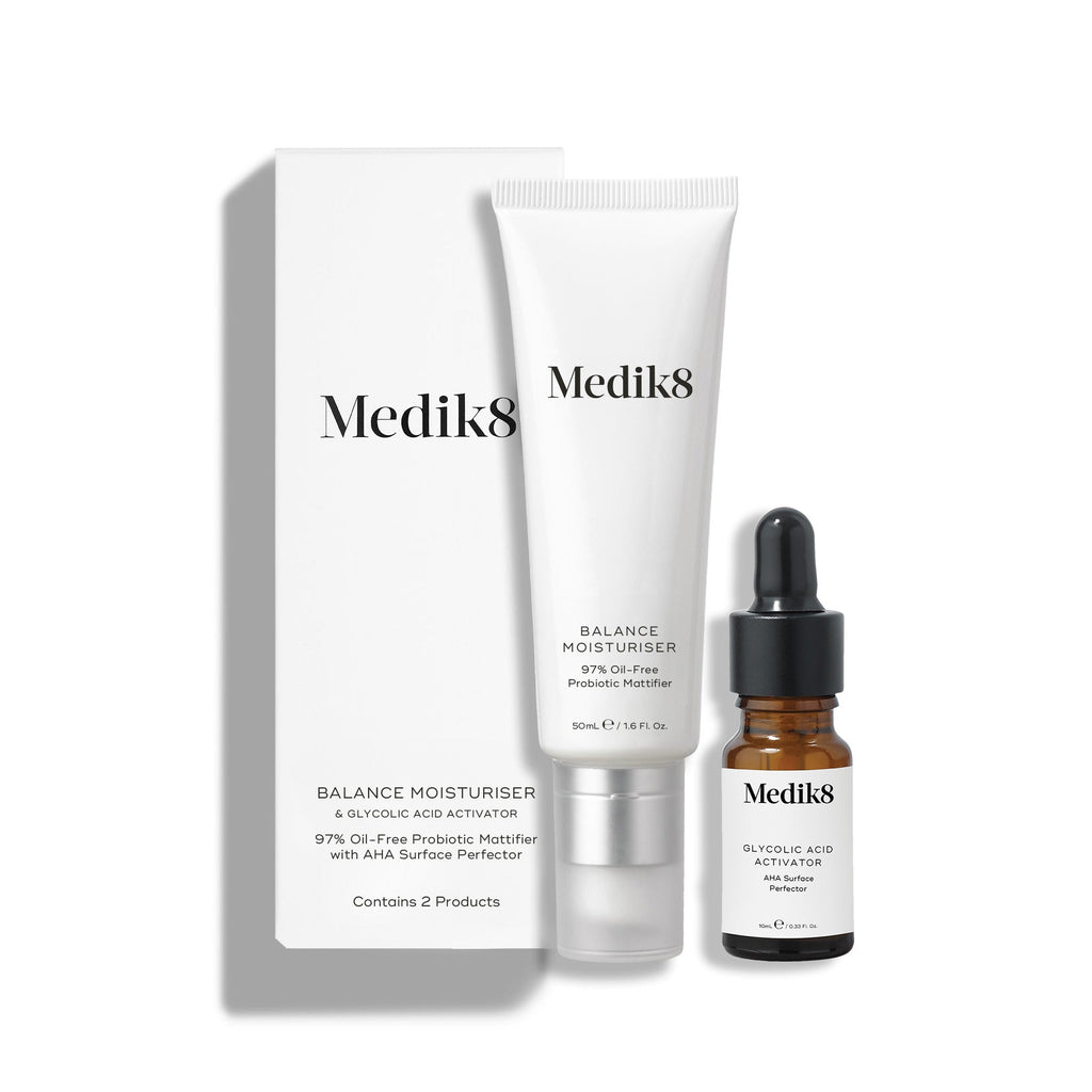 Bílá kartonová krabička stojí vedle bílé tuby Balance Moisturiser a malé hnědé skleněné lahvičky Glycolic Acid Activator.