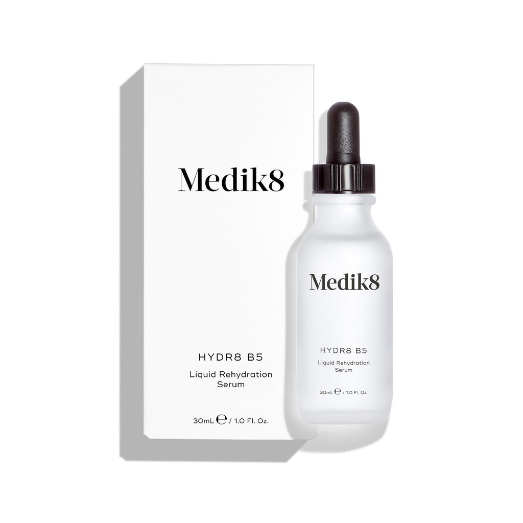 Lahvička Medik8 Hydr8 B5 stojí před svou odpovídající bílou krabičkou na čistém bílém pozadí. Text na obou označuje produkt jako 30ml „Liquid Rehydration Serum“ (tekuté rehydratační sérum).