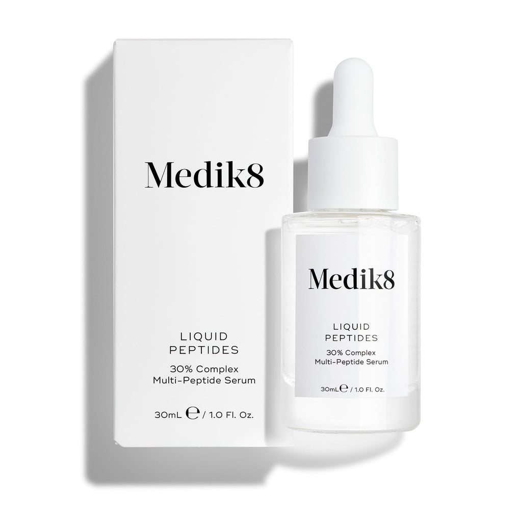 Průhledná skleněná lahvička séra Liquid Peptides stojí před svou bílou produktovou krabičkou.