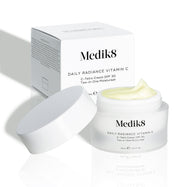 Otevřený kelímek Daily Radiance Vitamin C je zobrazen před svou krabičkou, přičemž je viditelná textura produktu.