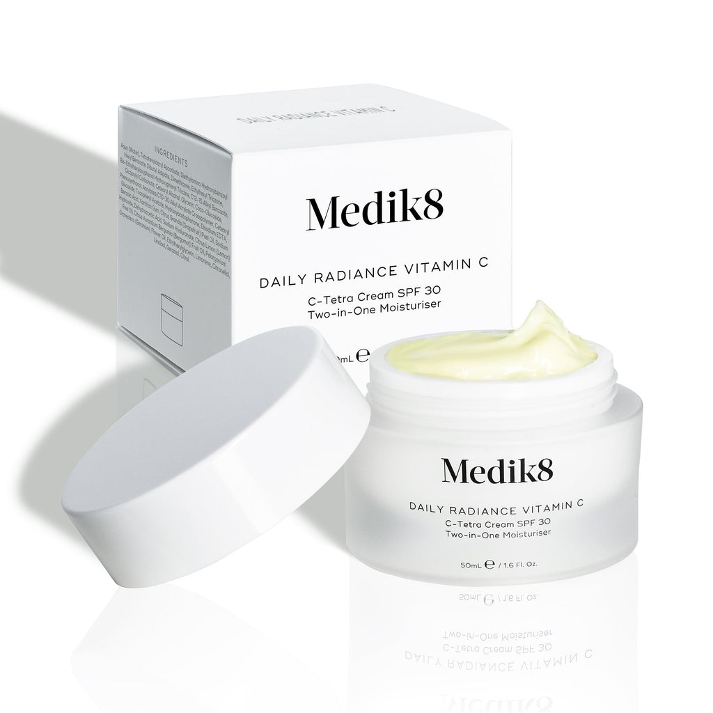 Otevřený kelímek Daily Radiance Vitamin C je zobrazen před svou krabičkou, přičemž je viditelná textura produktu.