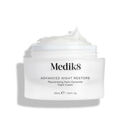 Otevřená dóza Medik8 Advanced Night Restore je zobrazena na čistém bílém pozadí.

Na vrchu je bohatá vrstva bílé krémové textury s jemným špičkovým tvarem, která zvýrazňuje její hladkou a regenerační konzistenci. Černý text na dóze uvádí „Rejuvenating Multi-Ceramide Night Cream“.