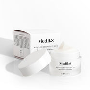 Otevřený kelímek krému Medik8 Advanced Night Eye stojí vedle své krabičky na bílém pozadí. Text zdůrazňuje složení „Rejuvenating Eye Cream“ (omlazující oční krém) a objem 15 ml.