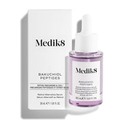 Lahvička séra Medik8 Bakuchiol Peptides naplněná fialovou tekutinou stojí vedle své bílé vnější krabičky na čistém bílém pozadí.