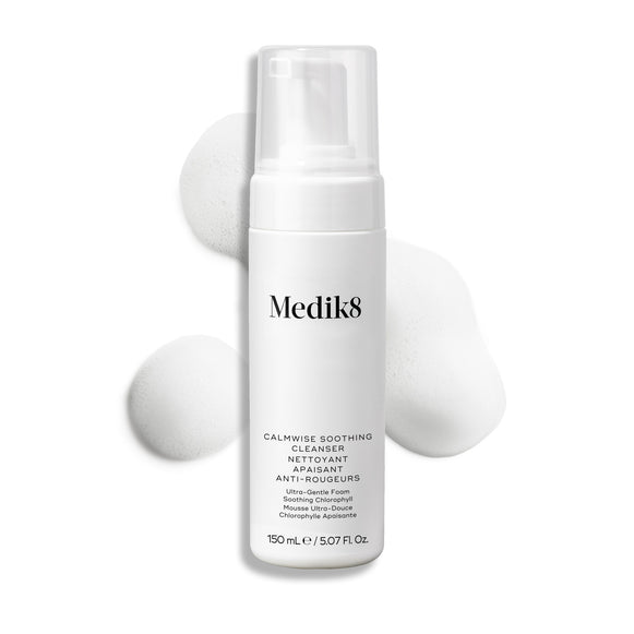 Lahvička čisticího přípravku Medik8 Calmwise Soothing Cleanser s pumpičkou je zobrazena na bílém pozadí s tahem bílé pěny za ní, který zdůrazňuje texturu produktu.-7