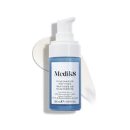 Lahvička séra Medik8 Niacinamide Peptides s bílým pumpičkovým uzávěrem je položena na bílém povrchu s tahem bílého séra za ní.