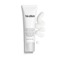 Tuba Medik8 Sleep Glycolic stojí na čistém bílém pozadí s vlnitým tahem a malou kapkou bílé krémové textury.