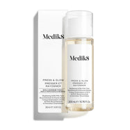 Lahvička tonika Medik8 Press & Glow stojí před odpovídající bílou krabičkou produktu na čistém bílém pozadí.