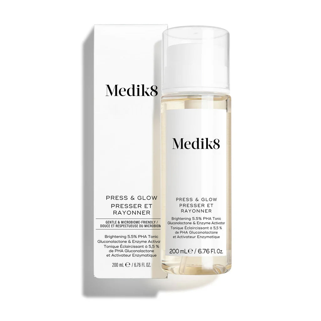 Lahvička tonika Medik8 Press & Glow stojí před odpovídající bílou krabičkou produktu na čistém bílém pozadí.
